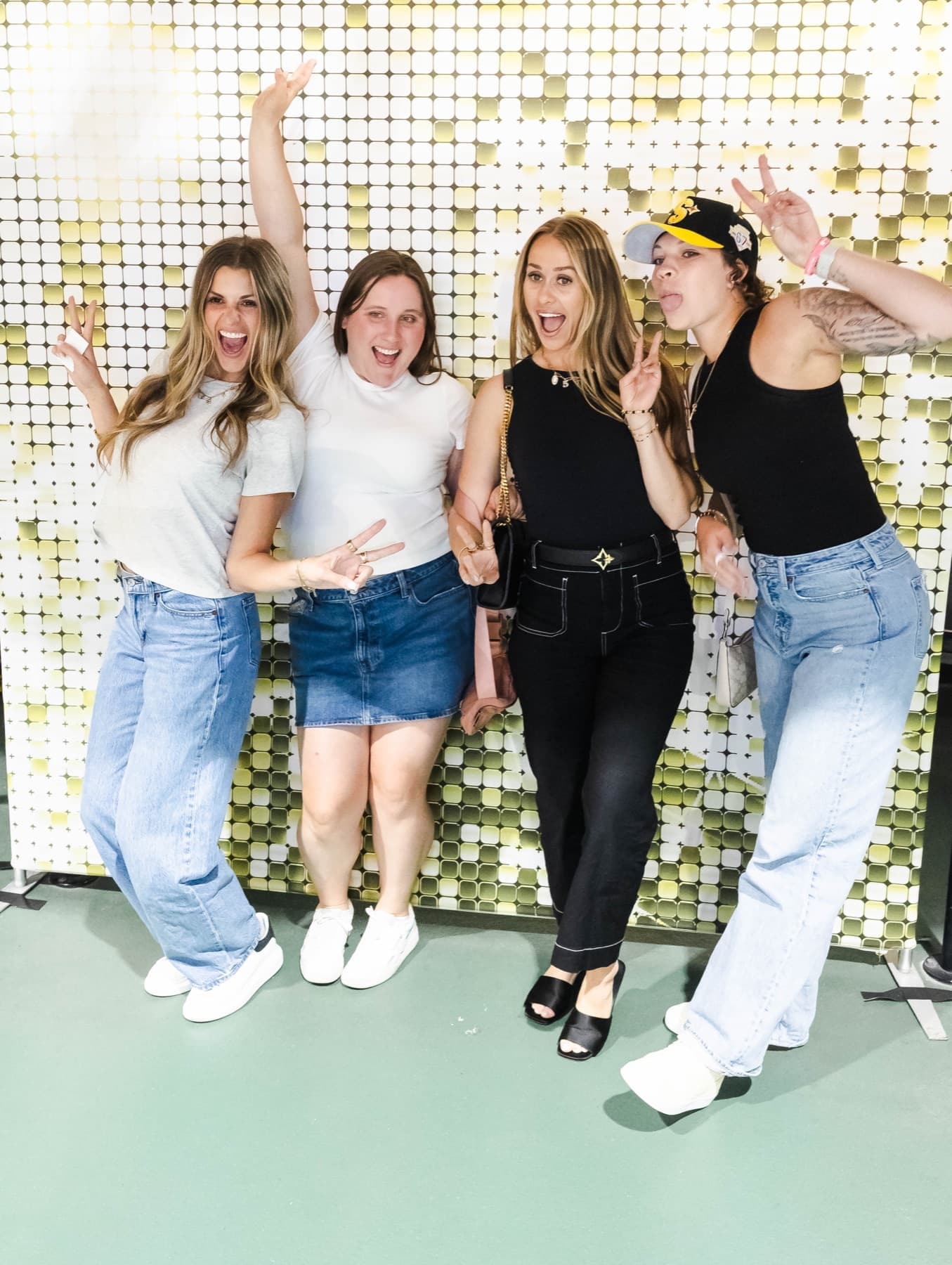 Guests posing in front of a gold shimmer wall at the Steelers Draft Party activation.
